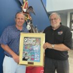 Harborfest Executive Director Dan Harrington presents the 2025 Harborfest poster to Daniel Dorsey, President of Eagle Beverage Co.